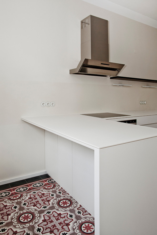 Moderne Küche mit Unterbauwaschbecken, flächenbündigen Schrankfronten, weißen Schränken, Küchenrückwand in Weiß, Küchengeräten aus Edelstahl und Halbinsel in Berlin