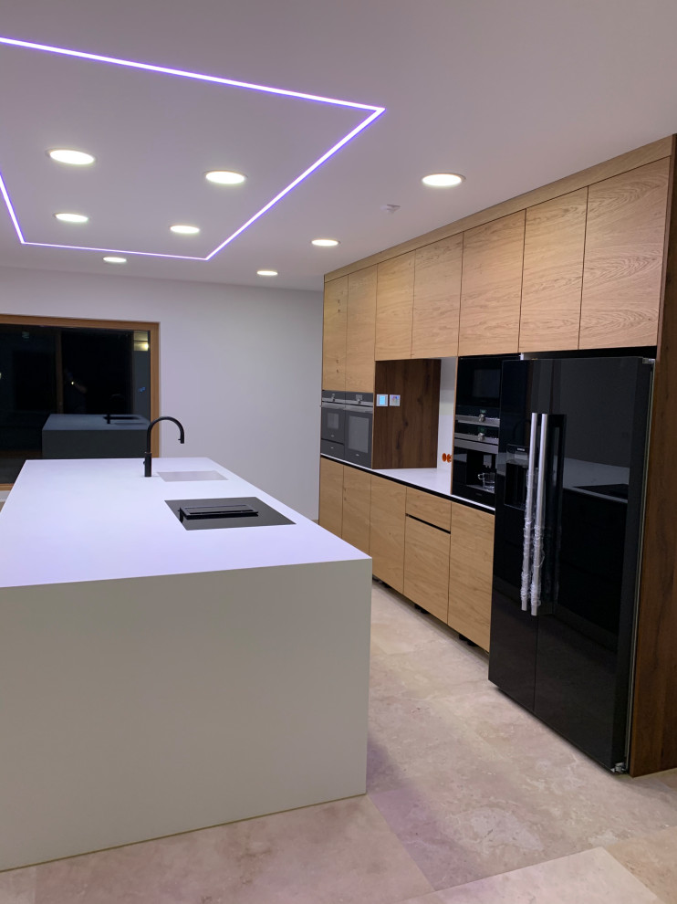 Photo of a large contemporary galley kitchen/diner in Stuttgart with an integrated sink, flat-panel cabinets, grey cabinets, composite countertops, white splashback, wood splashback, black appliances, travertine flooring, an island, turquoise floors, white worktops and a drop ceiling.