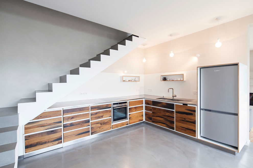 Example of a mid-sized trendy l-shaped open concept kitchen design in Dortmund with a double-bowl sink, flat-panel cabinets, dark wood cabinets, stainless steel countertops, white backsplash and no island