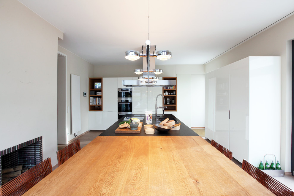 Immagine di una cucina minimal di medie dimensioni con lavello sottopiano, ante lisce, ante bianche e paraspruzzi bianco