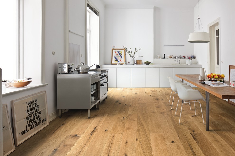 Moderne Küche ohne Insel in L-Form mit flächenbündigen Schrankfronten, weißen Schränken, braunem Holzboden, braunem Boden und weißer Arbeitsplatte