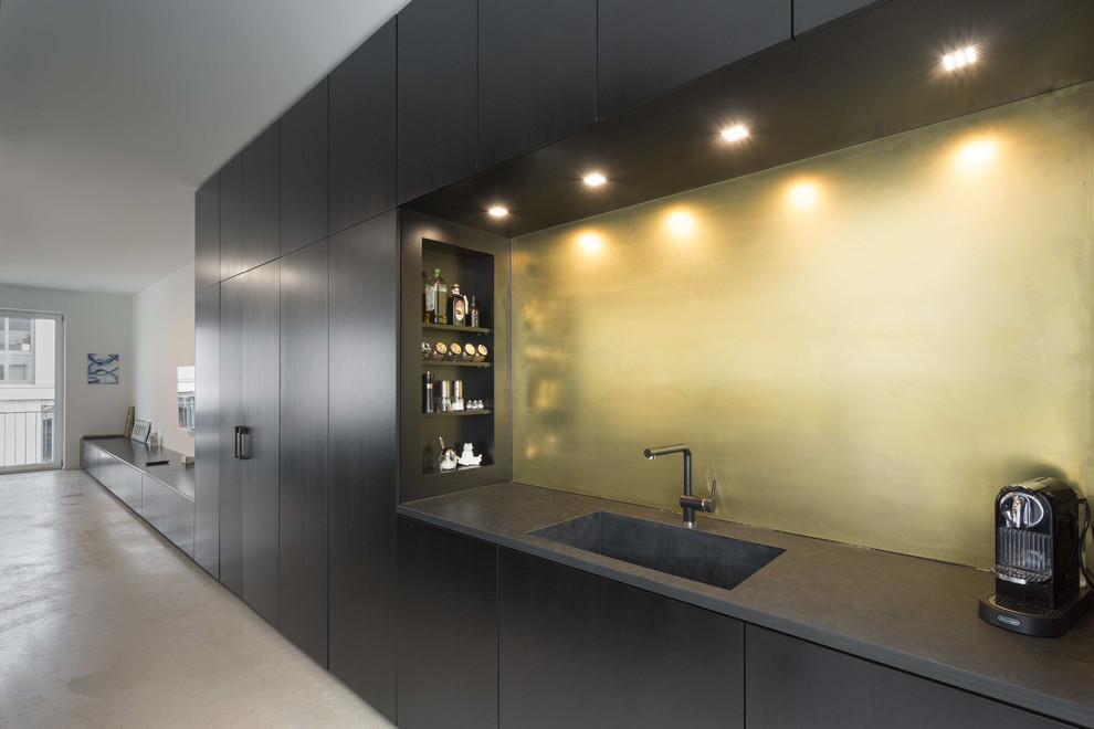 Photo of a contemporary kitchen in Other with black cabinets, composite countertops, metallic splashback, metal splashback, black appliances, an island, beige floors and black worktops.