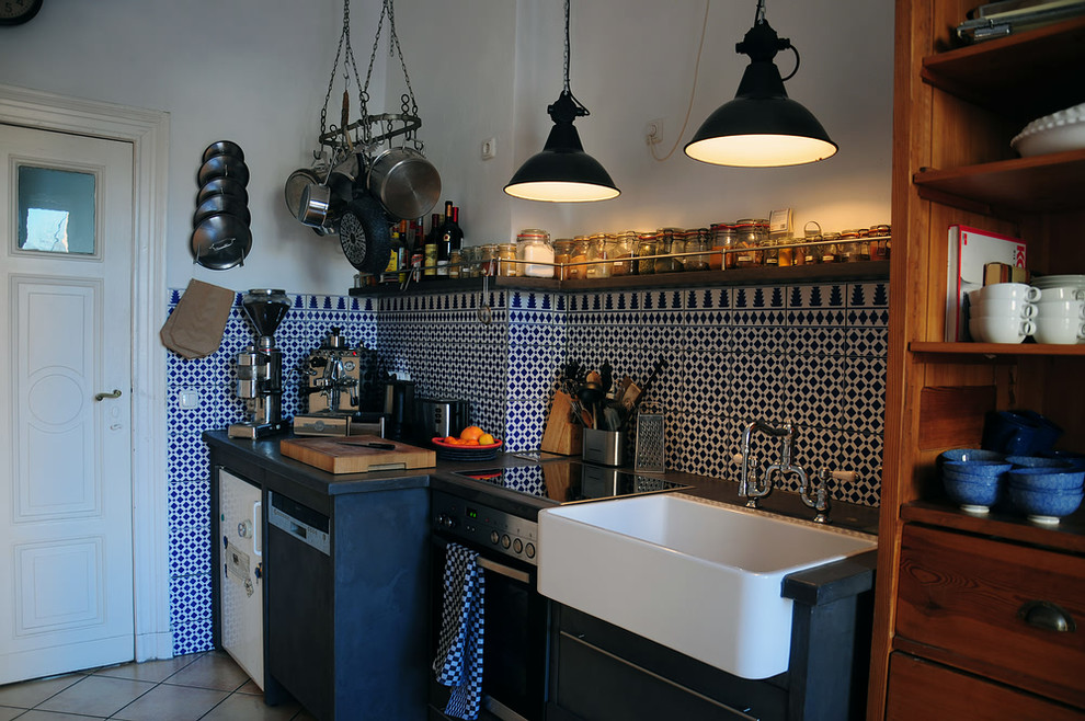 Idées déco pour une cuisine linéaire éclectique fermée et de taille moyenne avec un plan de travail en béton, une crédence bleue et une crédence en céramique.