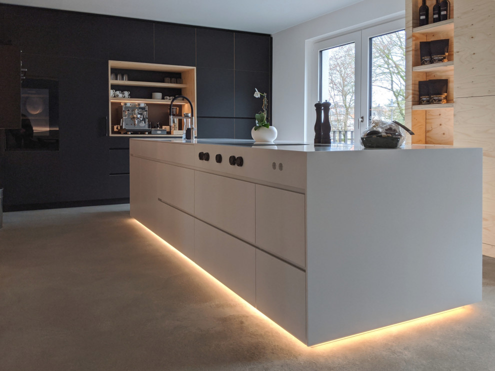 Inspiration for a large urban kitchen in Essen with flat-panel cabinets, black cabinets and an island.