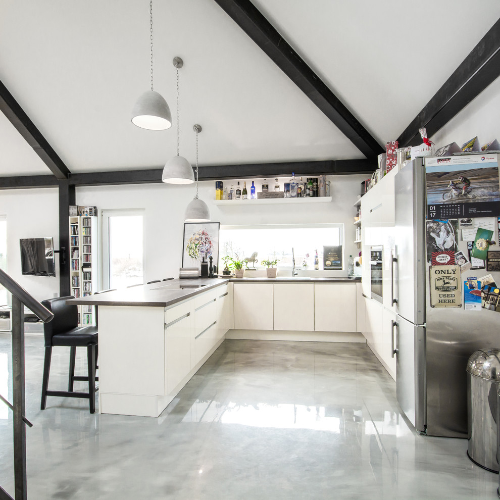 Esempio di una grande cucina minimal con ante lisce, ante bianche, pavimento grigio, top in legno, penisola e travi a vista