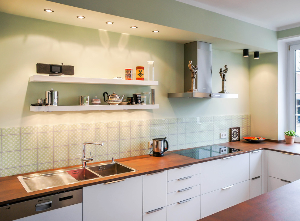 Idéer för att renovera ett mellanstort skandinaviskt kök, med släta luckor, en dubbel diskho, vita skåp, träbänkskiva, grönt stänkskydd, stänkskydd i glaskakel och integrerade vitvaror