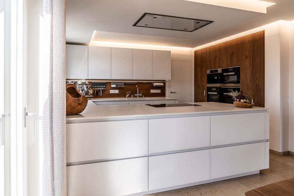 This is an example of a medium sized contemporary u-shaped kitchen in Nuremberg with a submerged sink, flat-panel cabinets, white cabinets, brown splashback, wood splashback, integrated appliances, a breakfast bar, brown floors and white worktops.