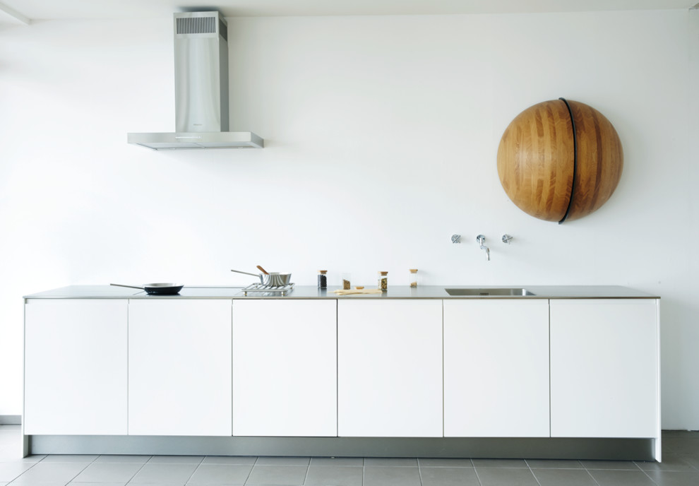 Idee per una cucina lineare minimalista di medie dimensioni con lavello integrato, ante lisce, ante bianche e paraspruzzi bianco