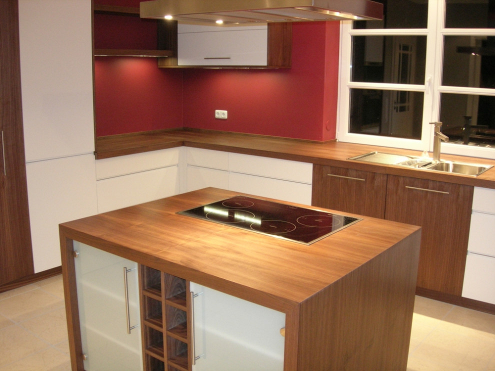 Cette image montre une cuisine ouverte design avec un placard à porte plane, un plan de travail en bois et îlot.