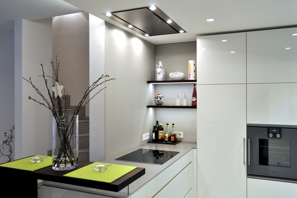 Offene, Mittelgroße Moderne Küche in U-Form mit weißen Schränken, Edelstahl-Arbeitsplatte und Küchengeräten aus Edelstahl in Essen