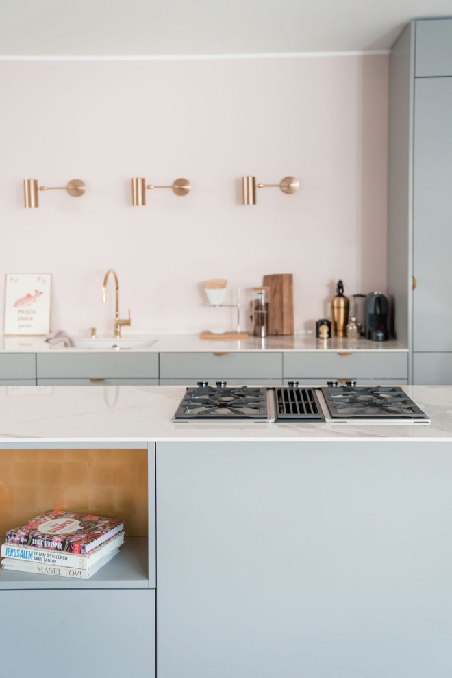 Photo of a medium sized scandinavian galley kitchen/diner in Other with a submerged sink, flat-panel cabinets, grey cabinets, pink splashback, black appliances, light hardwood flooring, an island and white worktops.