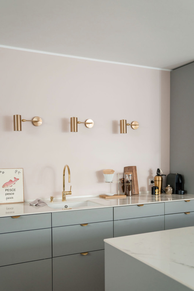 Immagine di una cucina nordica di medie dimensioni con lavello sottopiano, ante lisce, ante grigie, paraspruzzi rosa, elettrodomestici in acciaio inossidabile, parquet chiaro e top bianco