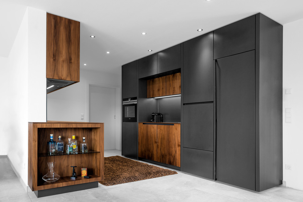 This is an example of a medium sized modern galley open plan kitchen in Munich with flat-panel cabinets, black cabinets, black splashback, black appliances, porcelain flooring, no island and grey floors.