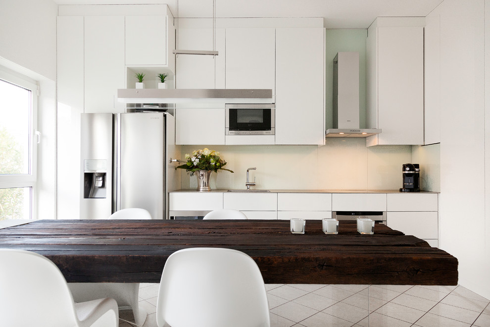 Imagen de cocina contemporánea cerrada sin isla con fregadero de un seno, puertas de armario blancas y electrodomésticos de acero inoxidable