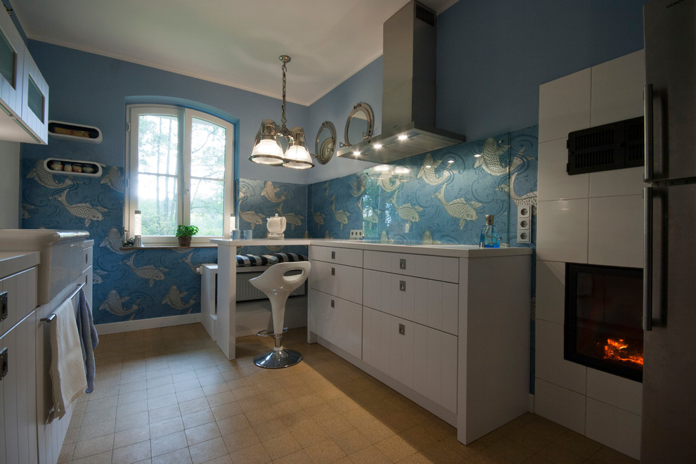 На фото: параллельная кухня среднего размера в современном стиле с плоскими фасадами, белыми фасадами, синим фартуком, фартуком из керамической плитки и обоями на стенах