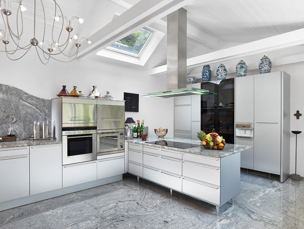 Geschlossene Moderne Küche mit flächenbündigen Schrankfronten, weißen Schränken, Küchenrückwand in Grau, Rückwand aus Stein, Küchengeräten aus Edelstahl und grauem Boden in Sonstige