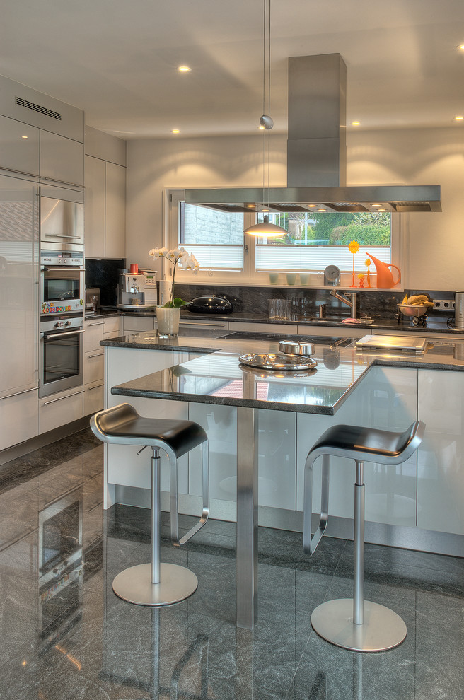 Esempio di una cucina lineare contemporanea con lavello sottopiano, ante bianche e top in granito