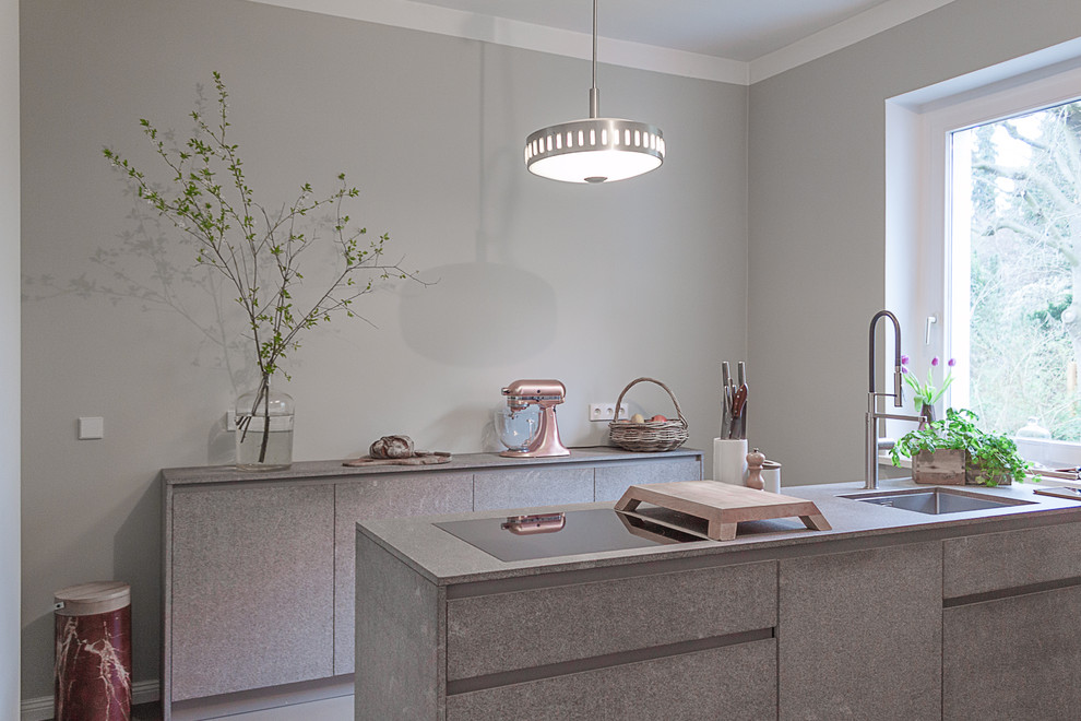 На фото: кухня-гостиная среднего размера в стиле модернизм с столешницей из известняка, бетонным полом и серым полом
