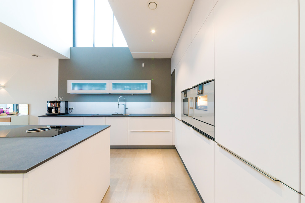 Стильный дизайн: огромная кухня в стиле модернизм с белыми фасадами - последний тренд