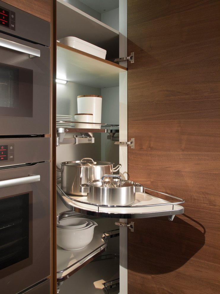 Foto de cocina contemporánea con armarios con paneles lisos, puertas de armario de madera en tonos medios y electrodomésticos de acero inoxidable