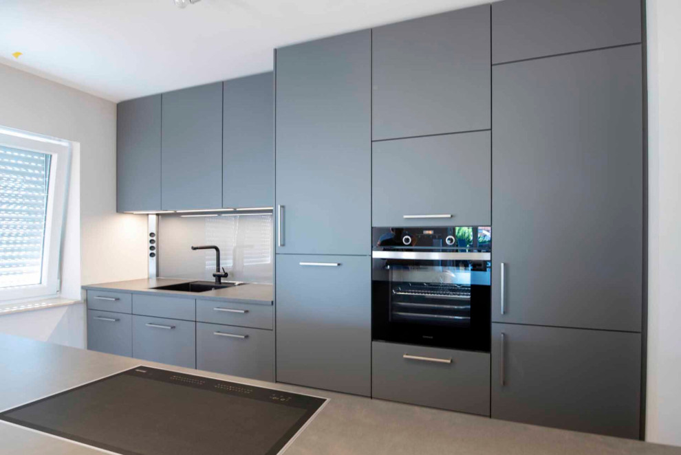 Inspiration for a medium sized contemporary single-wall open plan kitchen in Frankfurt with a built-in sink, flat-panel cabinets, grey cabinets, wood worktops, grey splashback, wood splashback, integrated appliances, a breakfast bar, grey worktops and a drop ceiling.