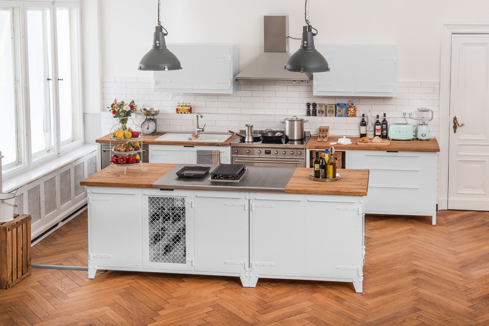Design ideas for a large industrial single-wall kitchen in Berlin with a built-in sink, flat-panel cabinets, white cabinets, wood worktops, white splashback, stainless steel appliances, an island and brown worktops.
