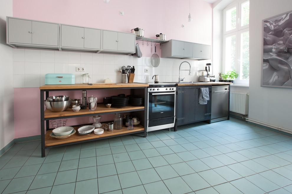 ベルリンにある高級な中くらいなインダストリアルスタイルのおしゃれなI型キッチン (ドロップインシンク、シルバーの調理設備、アイランドなし) の写真