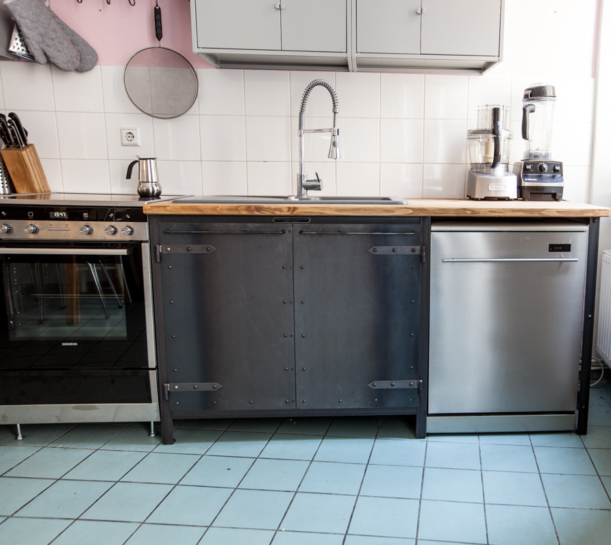 ベルリンにある高級な中くらいなインダストリアルスタイルのおしゃれなI型キッチン (ドロップインシンク、シルバーの調理設備、アイランドなし) の写真