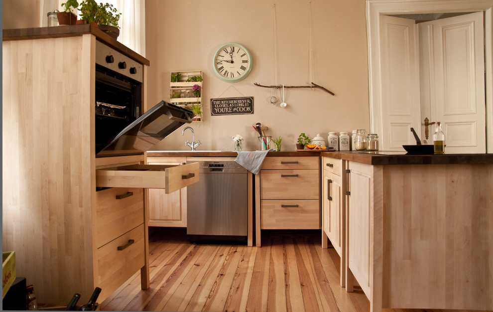 Immagine di una cucina nordica con top in legno, paraspruzzi in legno, lavello da incasso, elettrodomestici in acciaio inossidabile e penisola