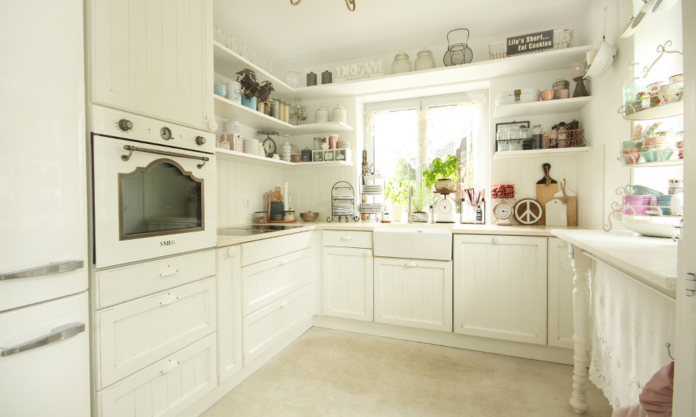 Bild på ett mellanstort shabby chic-inspirerat kök, med en dubbel diskho, luckor med profilerade fronter, vita skåp, marmorbänkskiva, vitt stänkskydd, stänkskydd i trä, vita vitvaror och marmorgolv