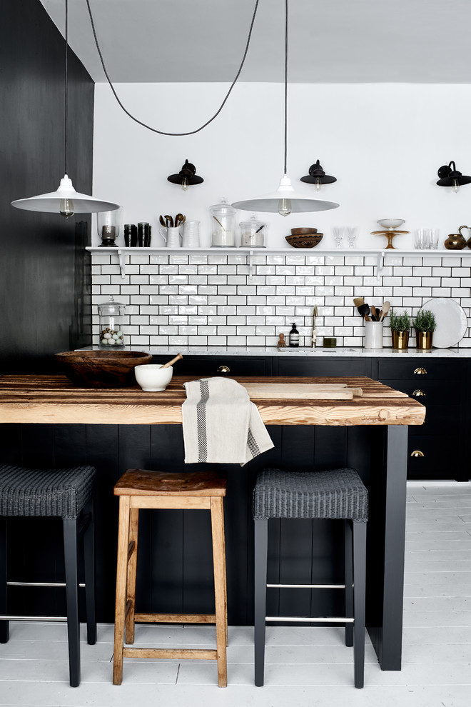 Imagen de cocina actual grande abierta con salpicadero blanco, salpicadero de azulejos tipo metro, suelo de madera pintada, una isla, fregadero de un seno y con blanco y negro