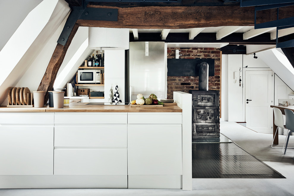 Immagine di una piccola cucina ad ambiente unico country con ante lisce, ante bianche, top in legno e penisola