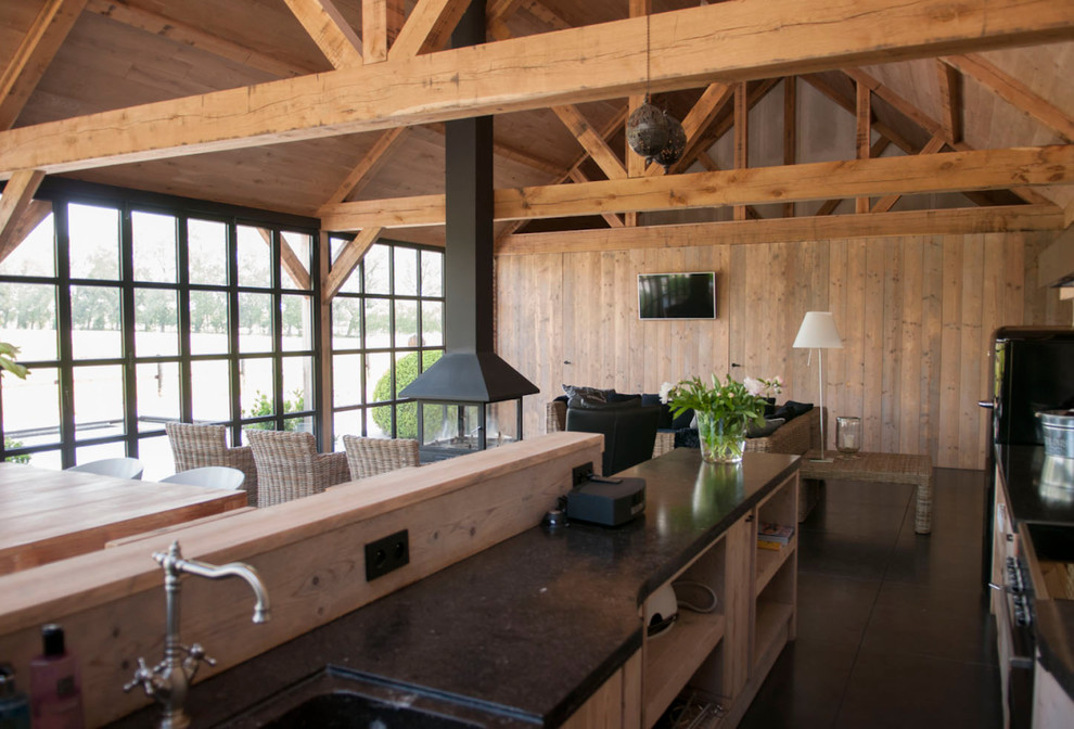Ejemplo de cocina de estilo de casa de campo de tamaño medio abierta con fregadero integrado, armarios abiertos, puertas de armario de madera oscura y península