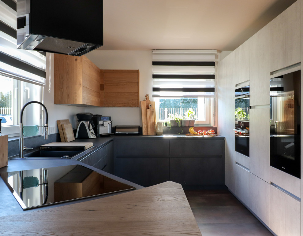 Idée de décoration pour une cuisine ouverte design en U de taille moyenne avec un placard à porte plane, des portes de placard grises et une péninsule.