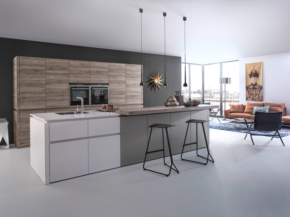 Design ideas for a medium sized modern open plan kitchen in Stuttgart with a double-bowl sink, flat-panel cabinets, dark wood cabinets, an island and black appliances.