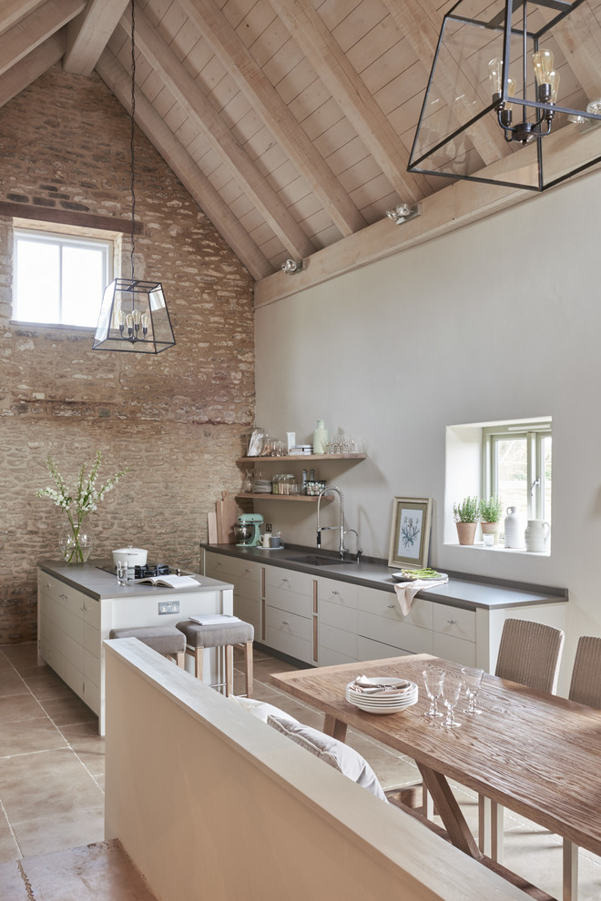 Expansive contemporary single-wall open plan kitchen in Other with flat-panel cabinets, white cabinets, an island and an integrated sink.