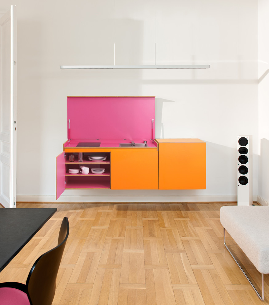 Foto på ett litet funkis linjärt kök och matrum, med en nedsänkt diskho, orange skåp och vitt stänkskydd