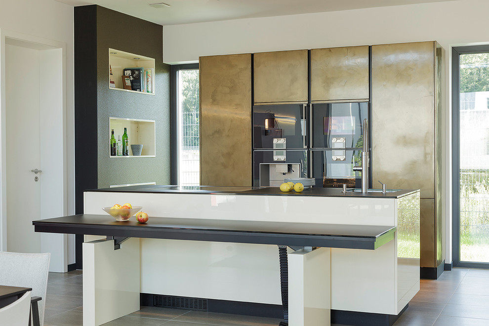 Contemporary open plan kitchen in Nuremberg with a submerged sink, flat-panel cabinets, an island and black appliances.