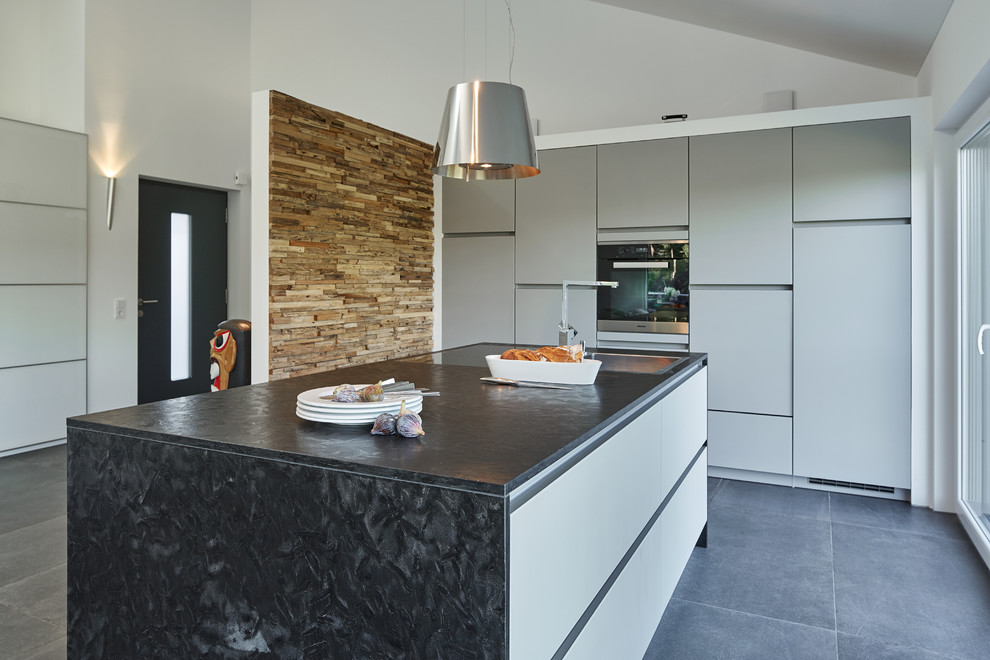 Moderne Wohnküche mit Kücheninsel und grauem Boden in Nürnberg