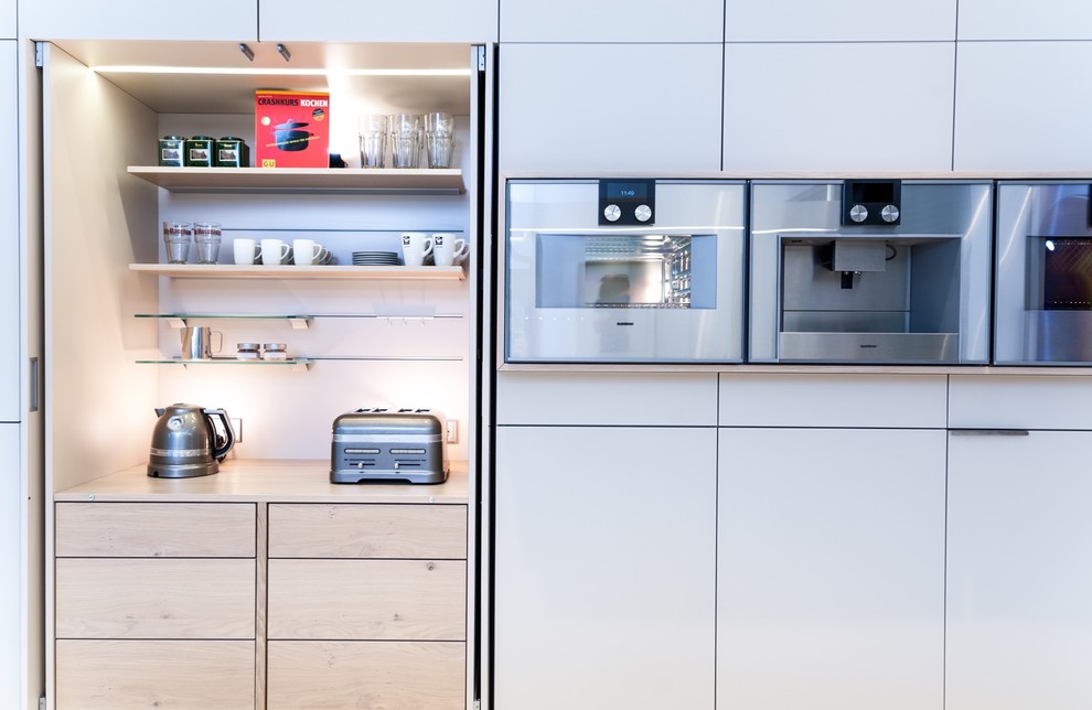Esempio di una cucina contemporanea con ante di vetro, ante beige e elettrodomestici in acciaio inossidabile