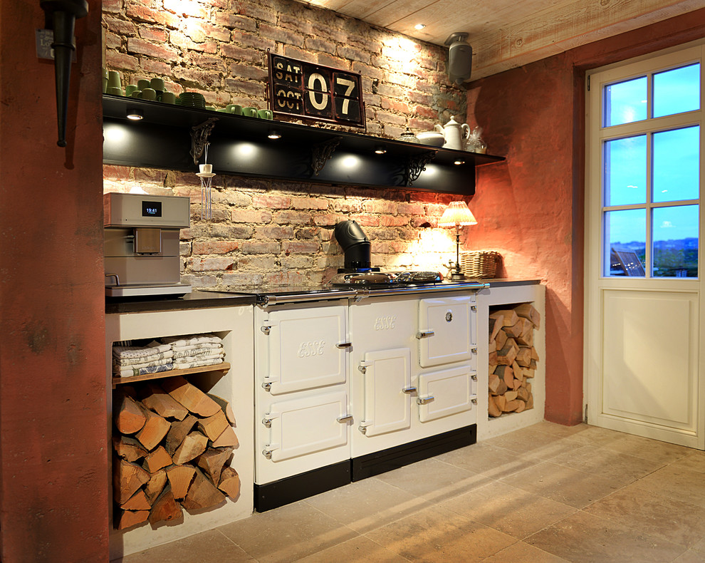 Foto på ett mellanstort lantligt kök, med en rustik diskho, luckor med upphöjd panel, skåp i ljust trä, bänkskiva i kalksten, svarta vitvaror, kalkstensgolv, en köksö och beiget golv