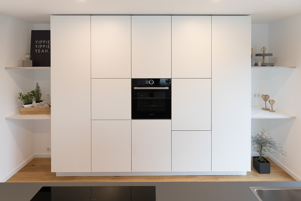 Foto di una grande cucina moderna con ante lisce, ante bianche, top in laminato, top blu, lavello integrato, pavimento in legno massello medio e pavimento marrone