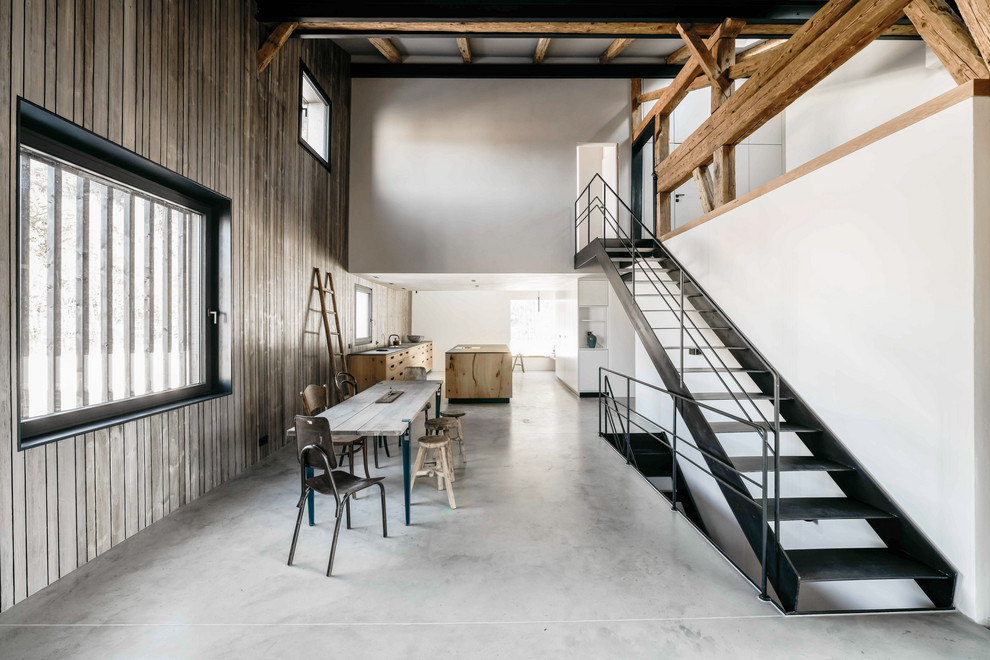 На фото: кухня в стиле рустика с бетонным полом, серым полом, обеденным столом, плоскими фасадами и островом