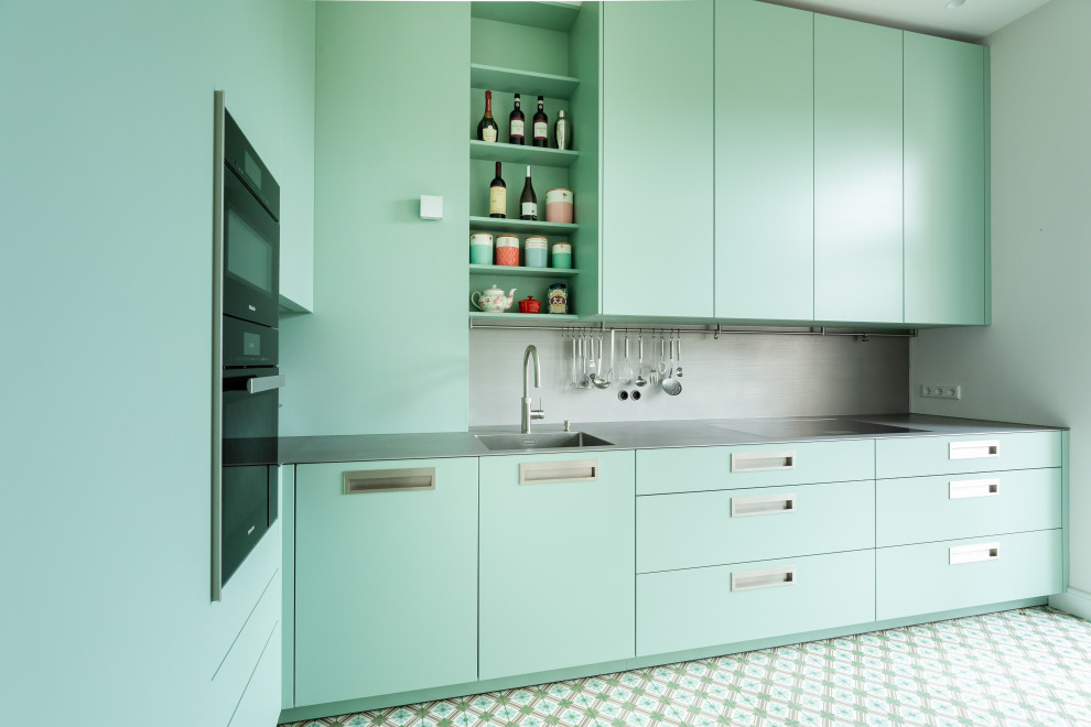 Inspiration for a small contemporary l-shaped turquoise floor enclosed kitchen remodel in Frankfurt with an integrated sink, flat-panel cabinets, turquoise cabinets, stainless steel countertops, gray backsplash, metal backsplash, black appliances and gray countertops
