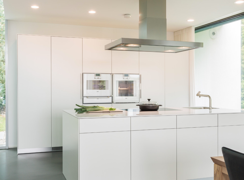 Zweizeilige, Mittelgroße Moderne Küche mit flächenbündigen Schrankfronten, weißen Schränken, weißen Elektrogeräten, Kücheninsel und integriertem Waschbecken in Stuttgart