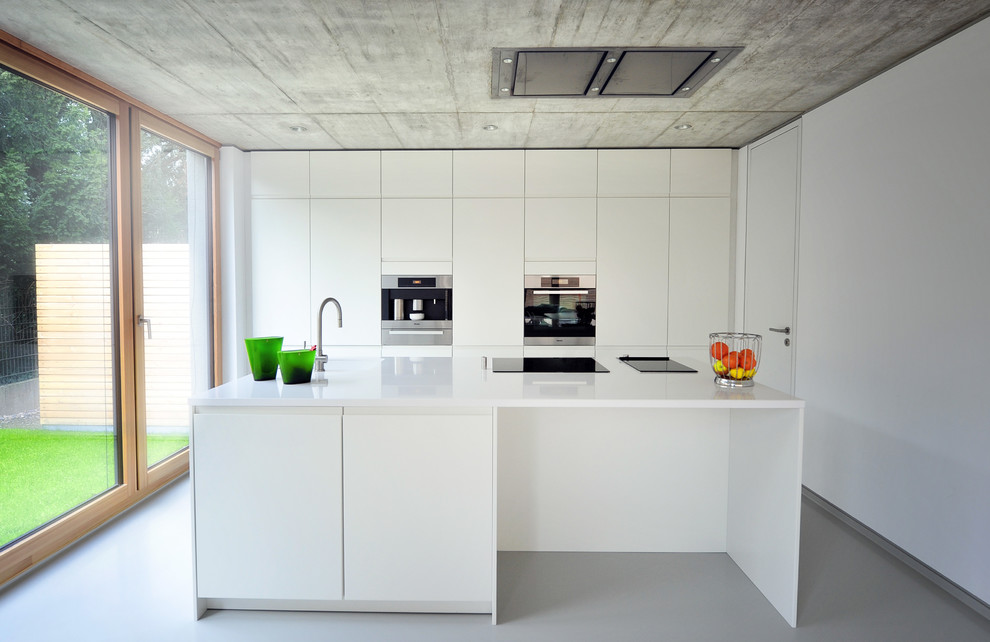 Modelo de cocina comedor contemporánea grande con fregadero integrado, puertas de armario blancas, salpicadero blanco, electrodomésticos de acero inoxidable, una isla y armarios con paneles lisos