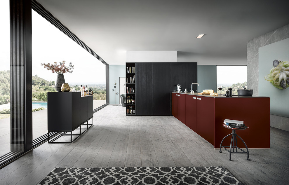 Design ideas for a large contemporary l-shaped open plan kitchen in Nuremberg with flat-panel cabinets, red cabinets, light hardwood flooring, a breakfast bar and grey floors.