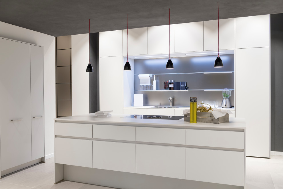 Mittelgroße Moderne Küche in L-Form mit Einbauwaschbecken, flächenbündigen Schrankfronten, weißen Schränken, Küchenrückwand in Grau, Kücheninsel, grauem Boden und weißer Arbeitsplatte in München