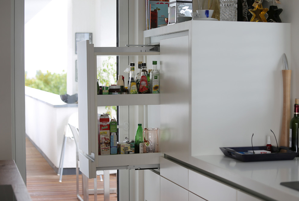 Cette photo montre une cuisine tendance avec des portes de placard blanches et un sol en bois brun.