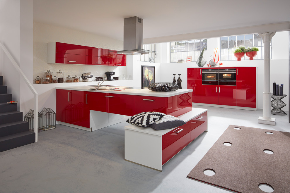 Zweizeilige, Große Moderne Küche mit roten Schränken, Küchenrückwand in Weiß, schwarzen Elektrogeräten und Halbinsel in Hamburg